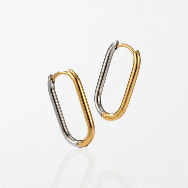 Pair of Saskia modern geometric contour hoops in duo tone: long oval hoops, each half gold and half silver