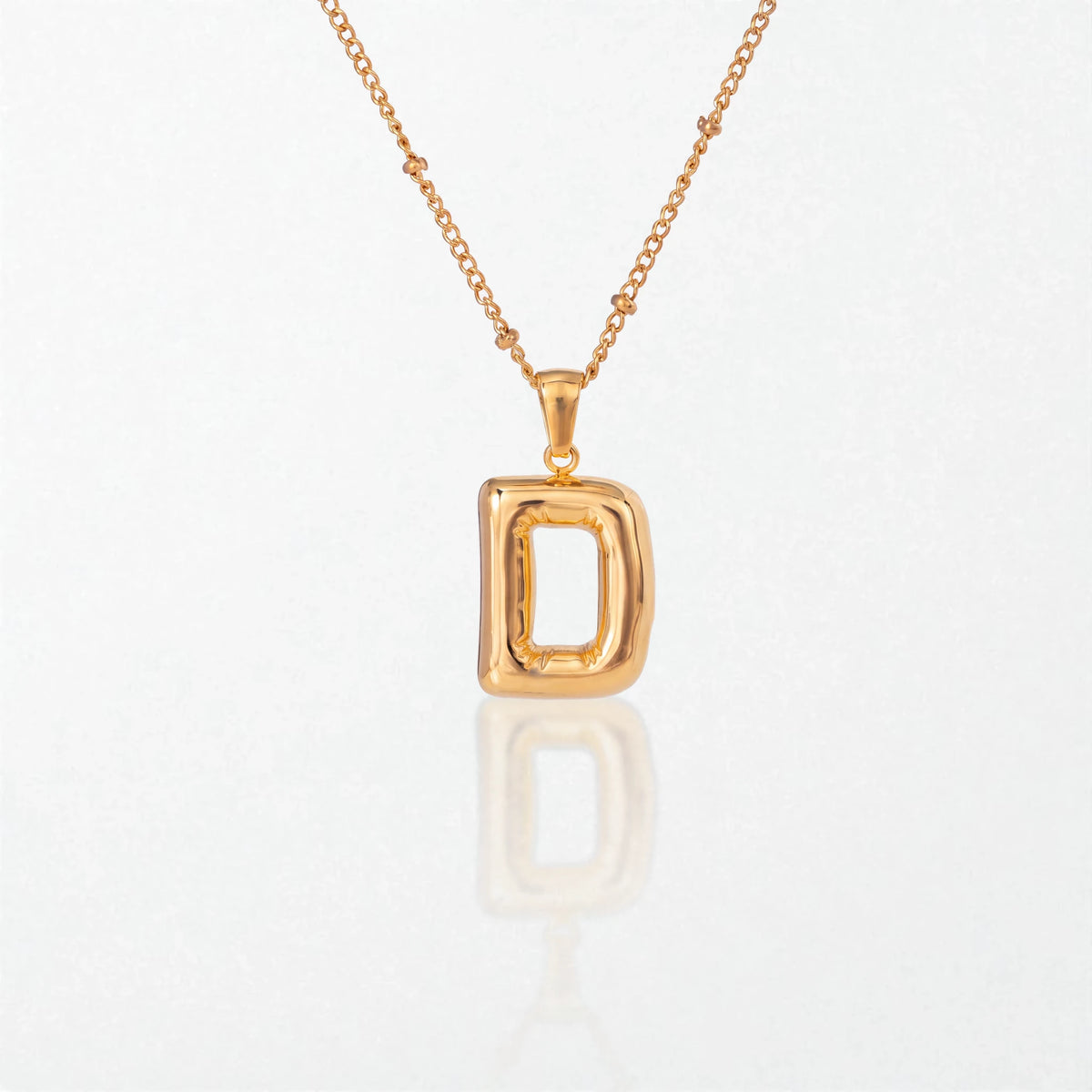 Bubble initial necklace with letter D pendant in 18K gold plated stainless steel, on a satellite chain