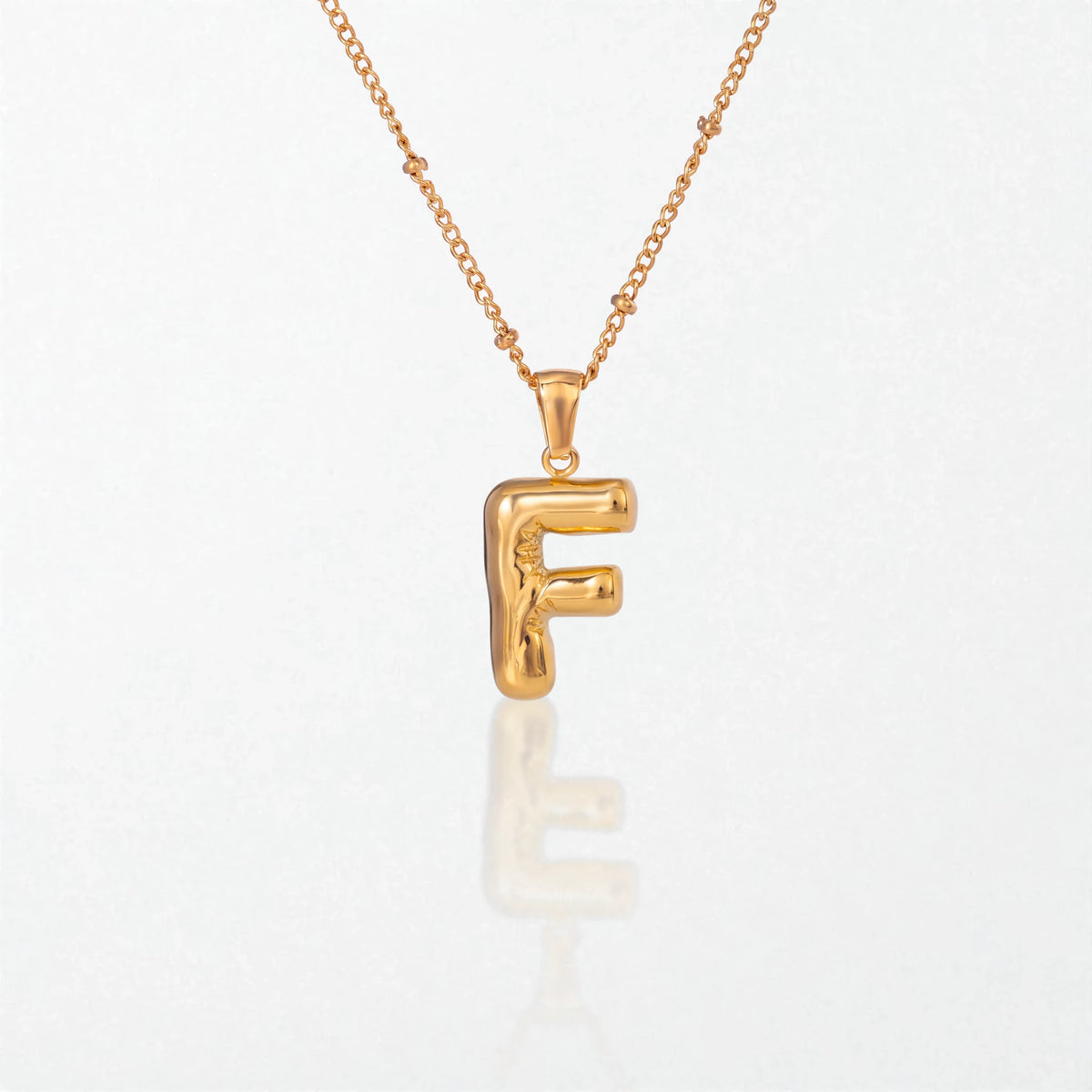 Bubble initial necklace with letter F pendant in 18K gold plated stainless steel, on a satellite chain