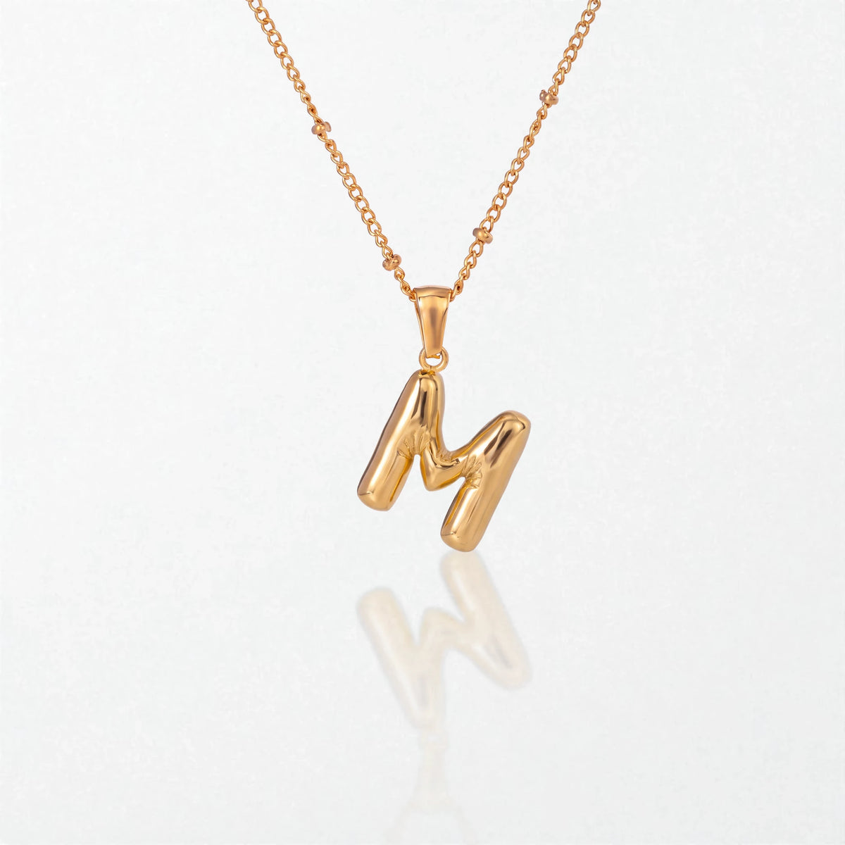 Bubble initial necklace with letter M pendant in 18K gold plated stainless steel, on a satellite chain