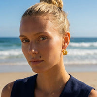 Chunky molten hoop earrings with crumpled texture in 18K gold plated stainless steel, worn on model