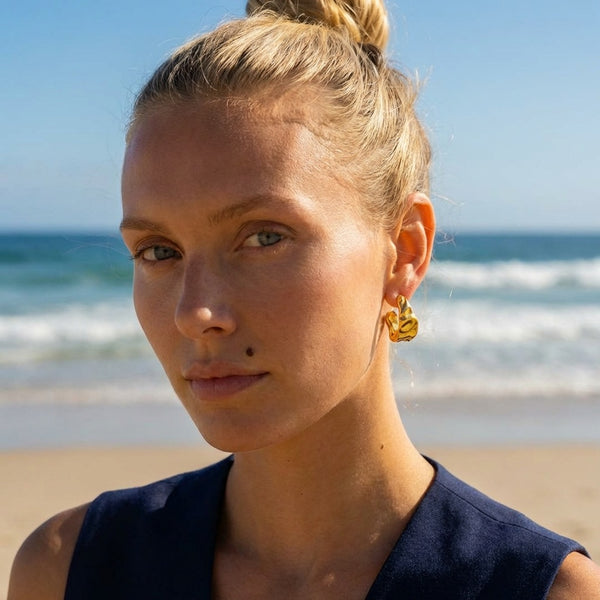Chunky molten hoop earrings with crumpled texture in 18K gold plated stainless steel, worn on model