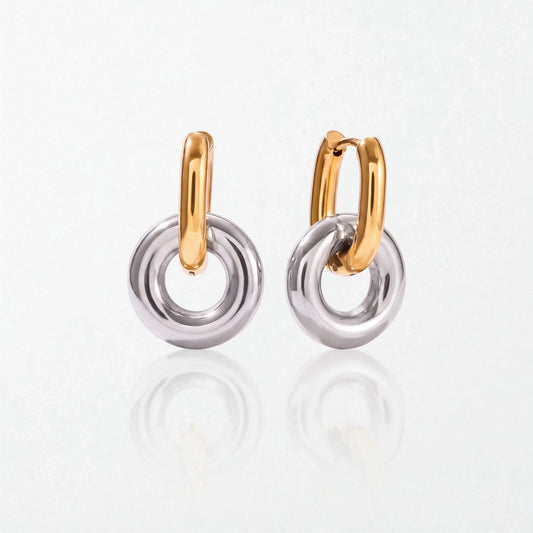 Pair of Alma donut drop hoops in duo tone: slim 18K gold oval hoops holding chunky polished silver donut rings