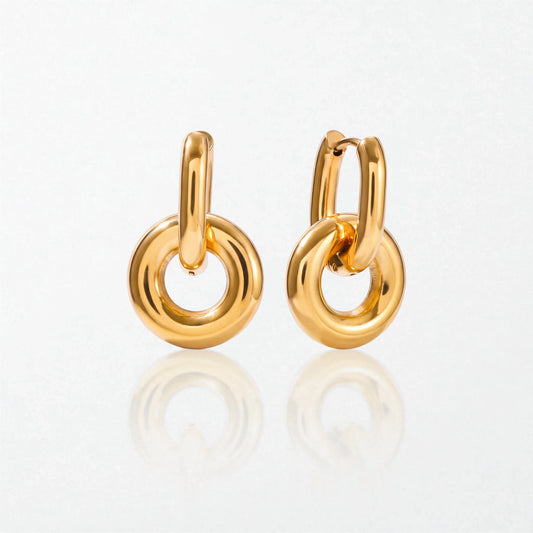 Pair of Alma drop hoops in 18K gold-plated waterproof stainless steel: a slim oval hinged hoop holding a chunky round donut ring