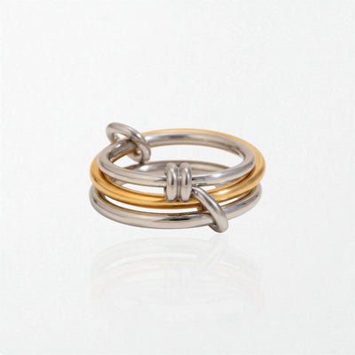Hermione intertwined link rings in duo tone: three linked bands, two in silver and one in gold, stacked together
