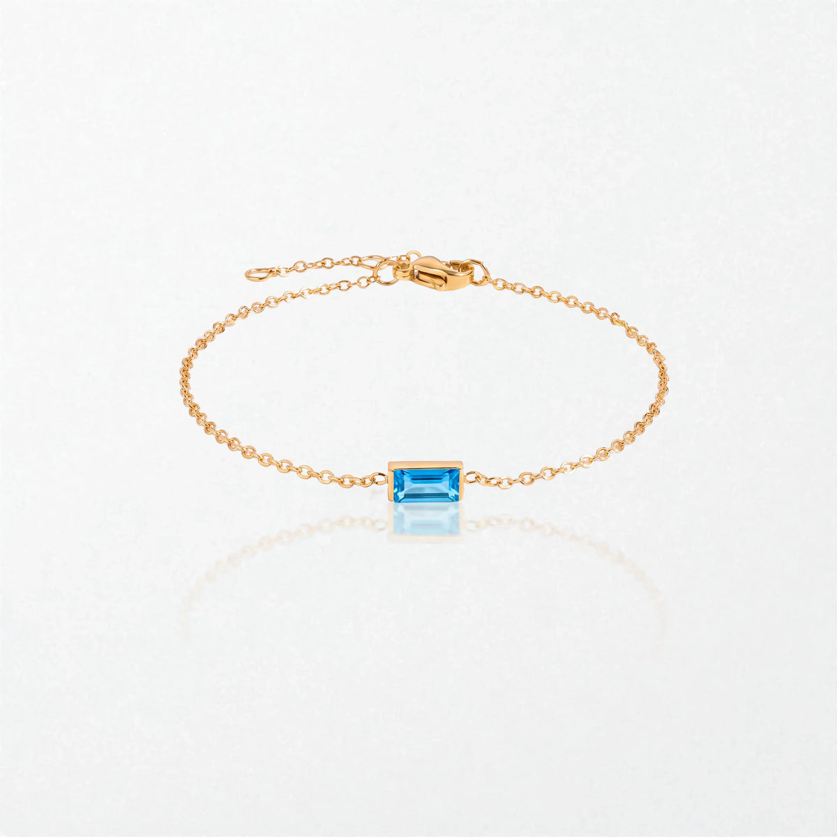 Juno birthstone bracelet in 14K gold-plated waterproof stainless steel with a small baguette blue topaz stone for December
