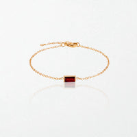 Juno birthstone bracelet in 14K gold-plated waterproof stainless steel with a small baguette garnet red stone for January