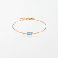 Juno birthstone bracelet in 14K gold-plated waterproof stainless steel with a small baguette aquamarine blue stone for March