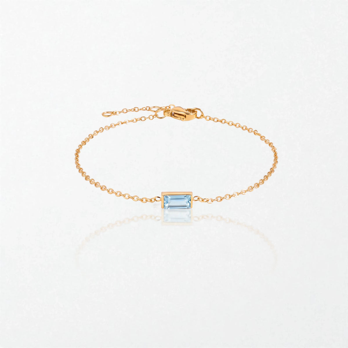 Juno birthstone bracelet in 14K gold-plated waterproof stainless steel with a small baguette aquamarine blue stone for March