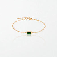 Juno birthstone bracelet in 14K gold-plated waterproof stainless steel with a small baguette emerald green stone for May