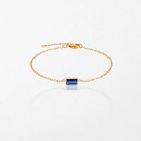 Juno birthstone bracelet in 14K gold-plated waterproof stainless steel with a small baguette sapphire blue stone for September