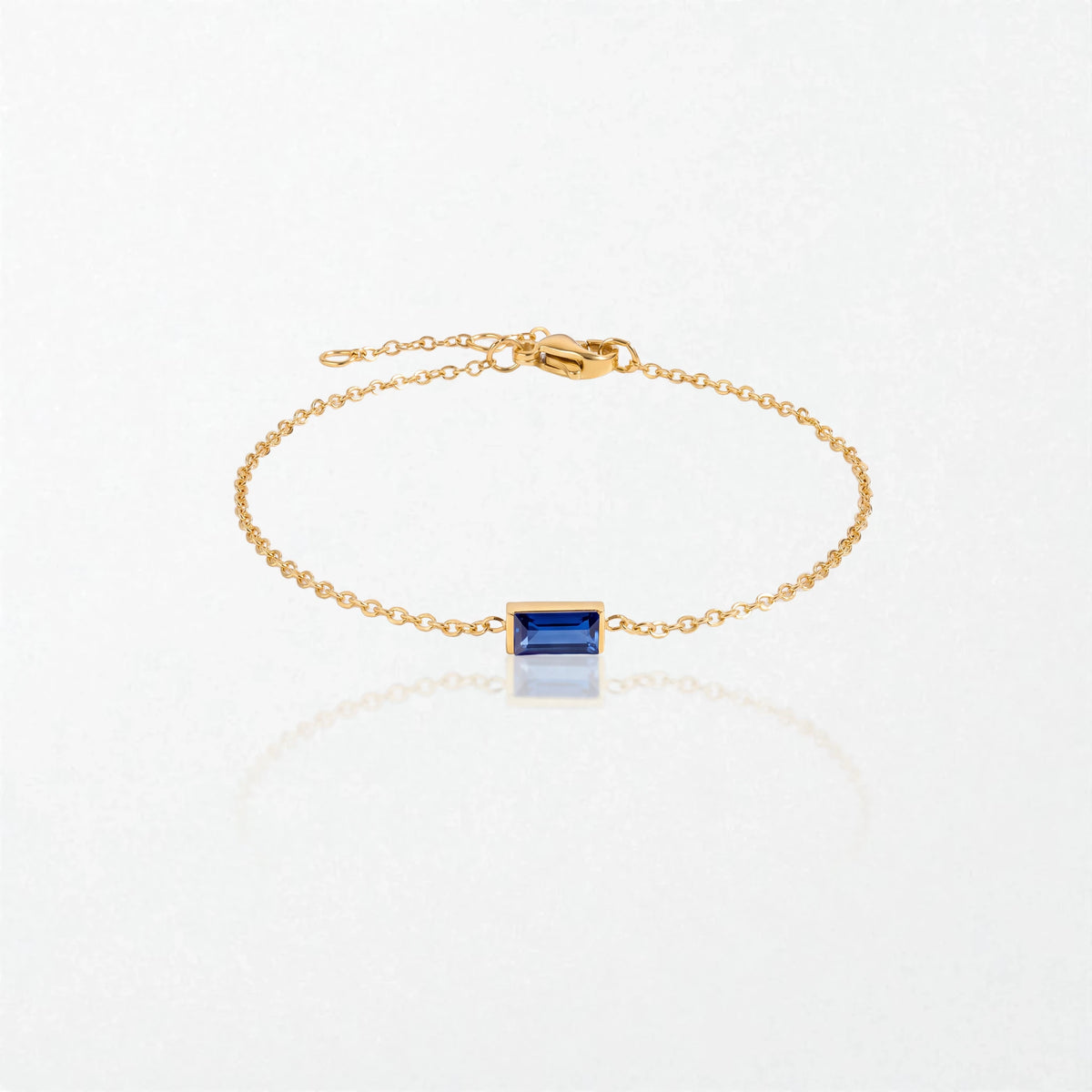 Juno birthstone bracelet in 14K gold-plated waterproof stainless steel with a small baguette sapphire blue stone for September
