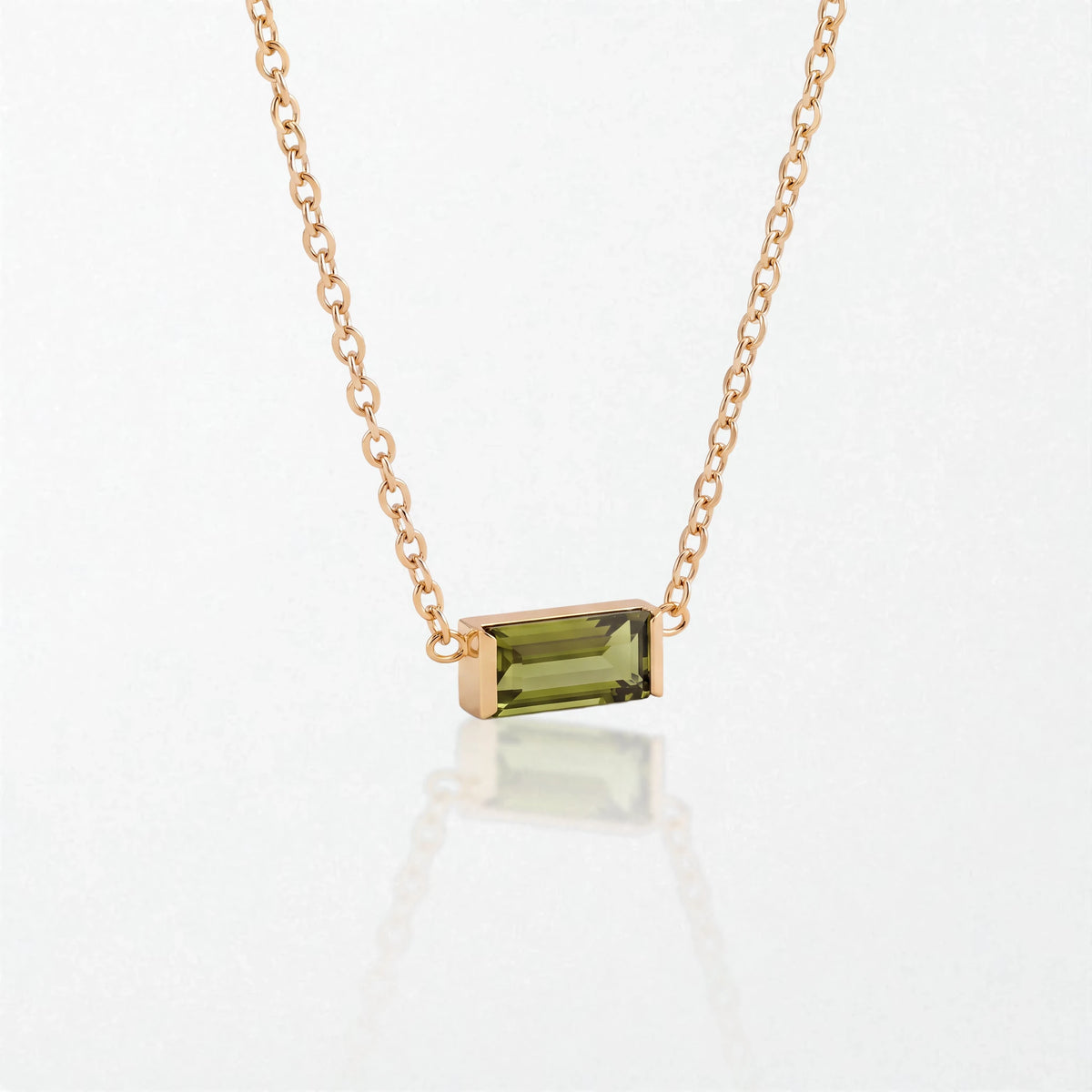 Juno birthstone necklace in 14K gold-plated waterproof stainless steel with a small baguette peridot green stone for August