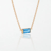 Juno birthstone necklace in 14K gold-plated waterproof stainless steel with a small baguette blue topaz stone for December