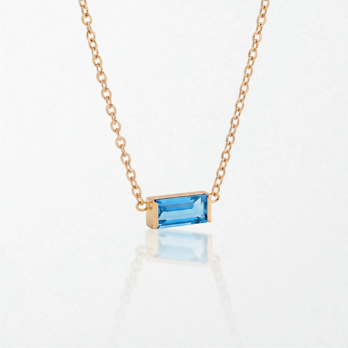 Juno birthstone necklace in 14K gold-plated waterproof stainless steel with a small baguette blue topaz stone for December