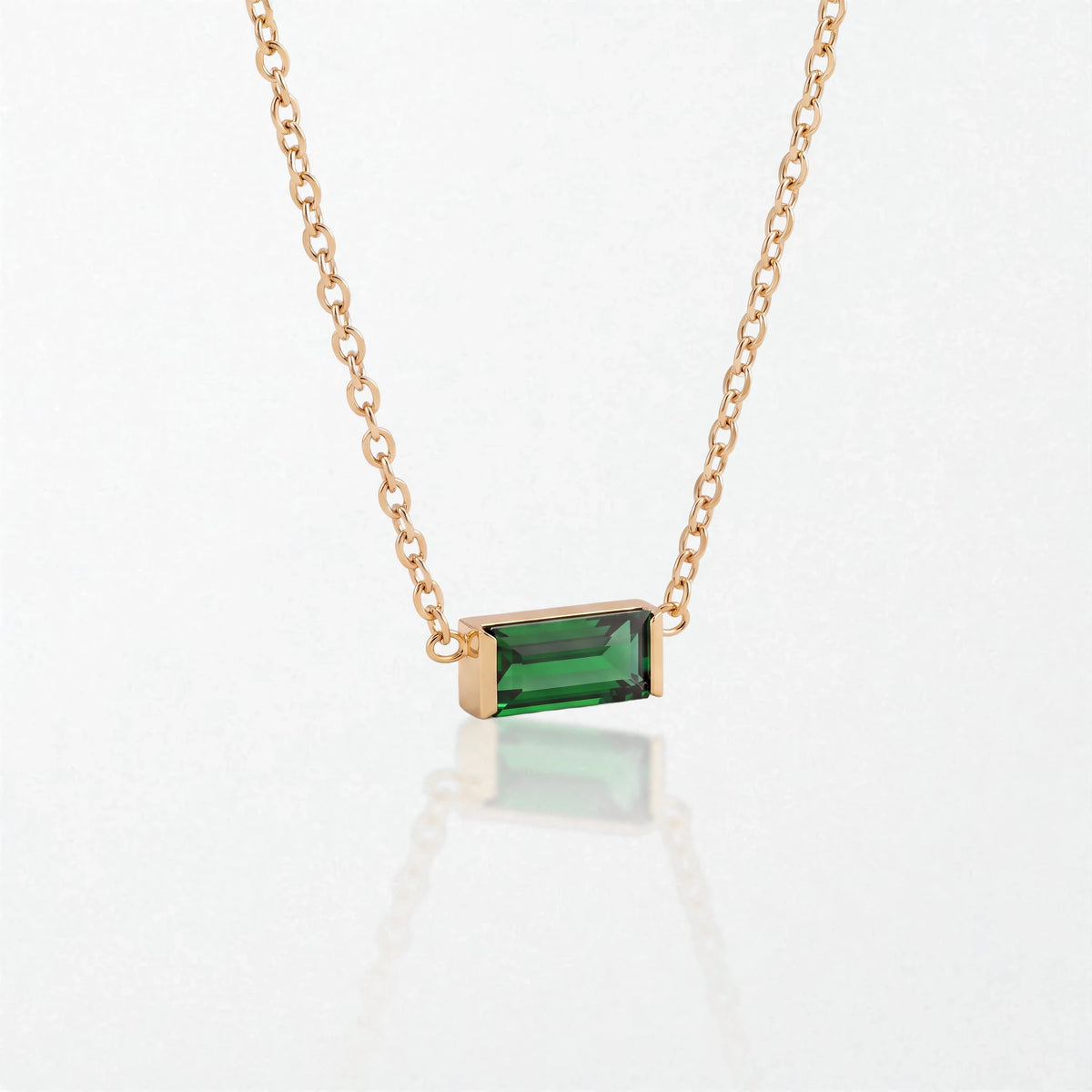 Juno birthstone necklace in 14K gold-plated waterproof stainless steel with a small baguette emerald green stone for May