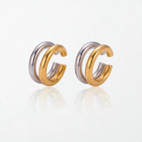 Pair of Roxanne double ear cuffs: two fused round tubes, one polished silver and one 18K gold, worn without a piercing