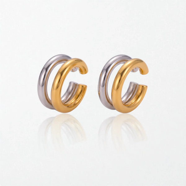 Pair of Roxanne double ear cuffs: two fused round tubes, one polished silver and one 18K gold, worn without a piercing