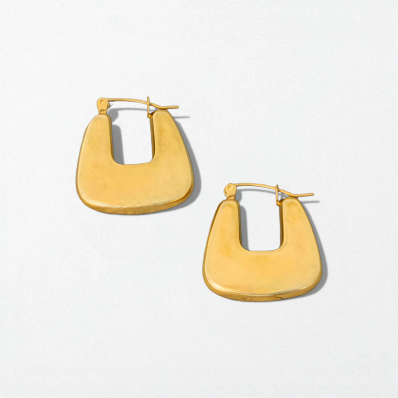 Pair of yellow hoop earrings on a light gray background