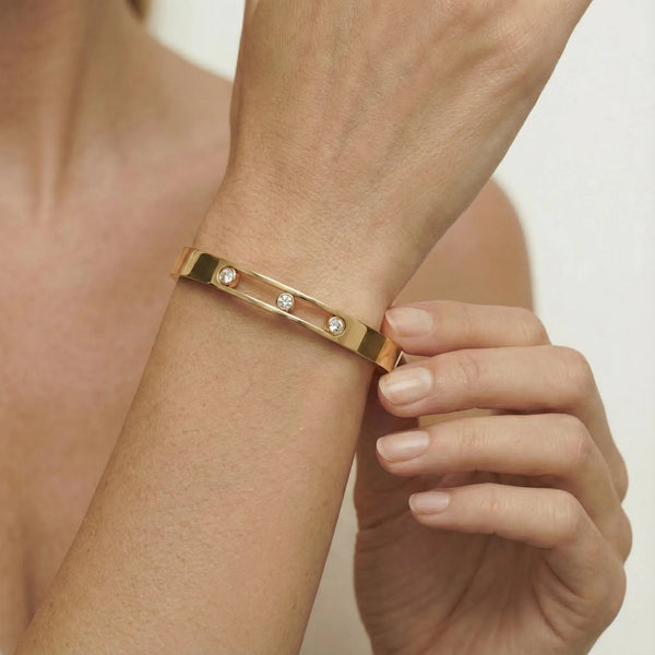 Close up of the central channel featuring three movable cubic zirconia crystals within the 18K gold plated track