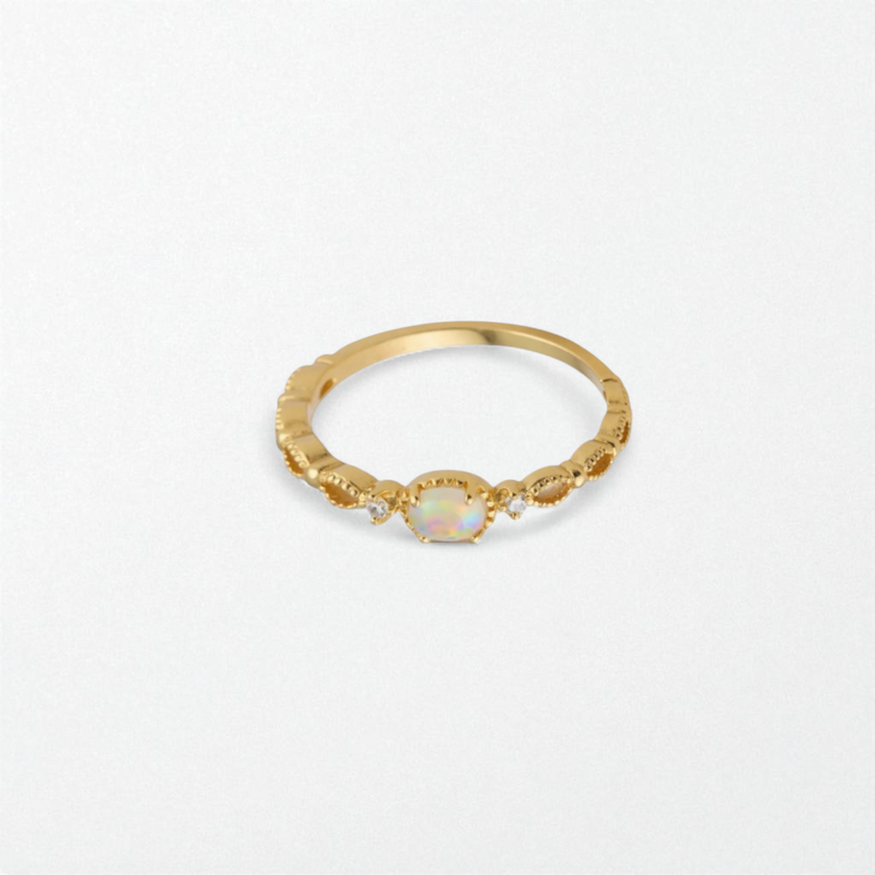 Gold ring with a moonstone gemstone on a light gray background