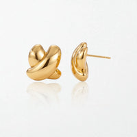 Pair of Esme sculptural crossed stud earrings in 18K gold-plated waterproof stainless steel, two glossy loops crossing in a knot