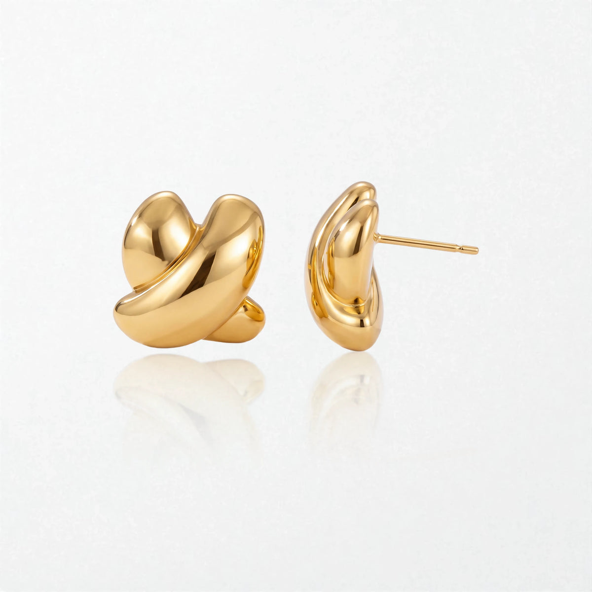 Pair of Esme sculptural crossed stud earrings in 18K gold-plated waterproof stainless steel, two glossy loops crossing in a knot