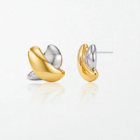 Pair of Esme sculptural crossed stud earrings in duo tone: a glossy gold loop crossing a polished silver loop
