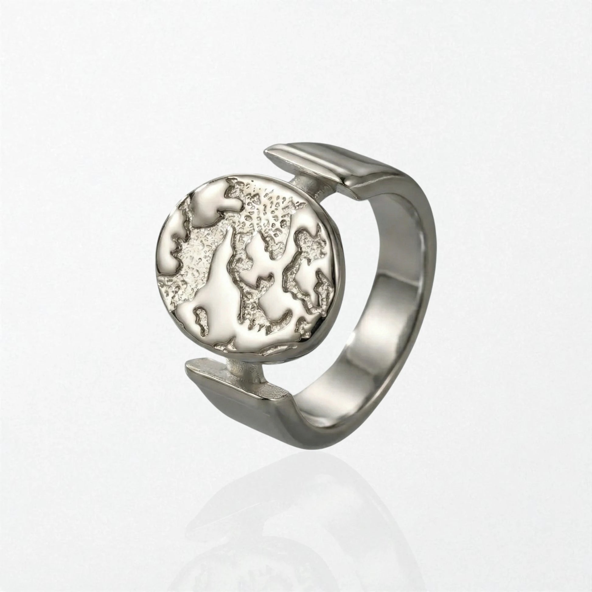 Sculptural statement ring with textured globe disc suspended in open band, stainless steel design