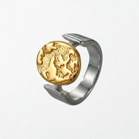 Sculptural statement ring in 18k gold and a high silver finish with textured globe disc suspended in open band, stainless steel design