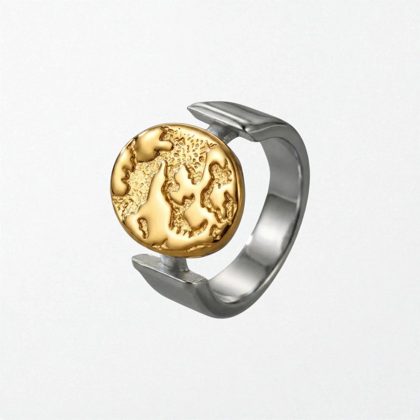 Sculptural statement ring in 18k gold and a high silver finish with textured globe disc suspended in open band, stainless steel design