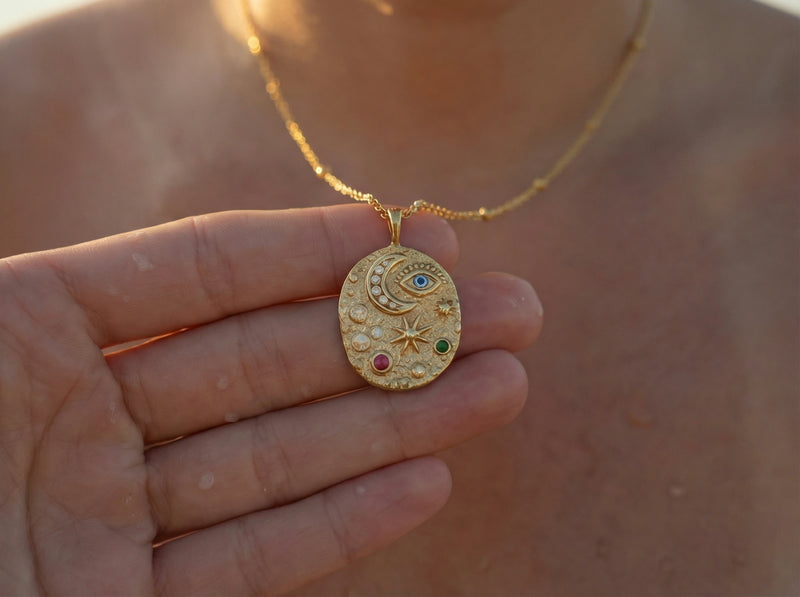 Close up of colourful cubic zirconia stones and evil eye protection symbol on a molten gold pendant